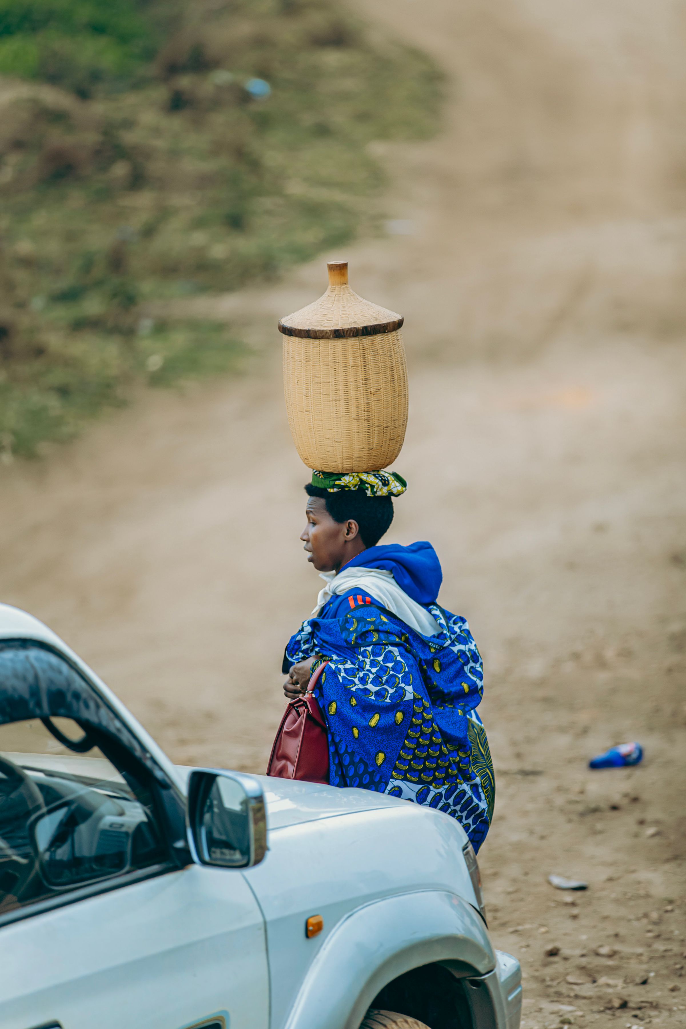 A Kenyan woman carries a handwoven basket, part of the artisan craft traditions Kenya House champions